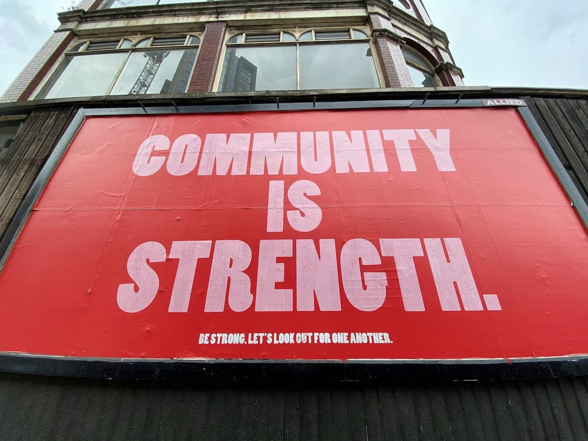 A red billboard reading: community is strength