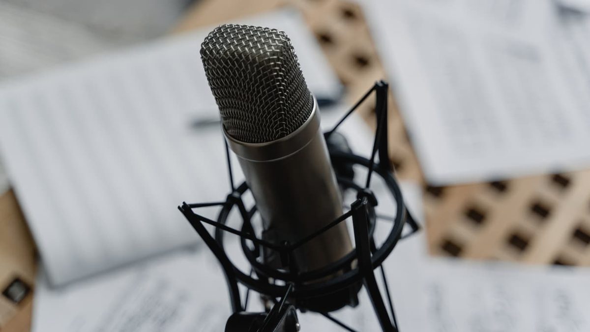 A condenser microphone on a shock mount over sheet music