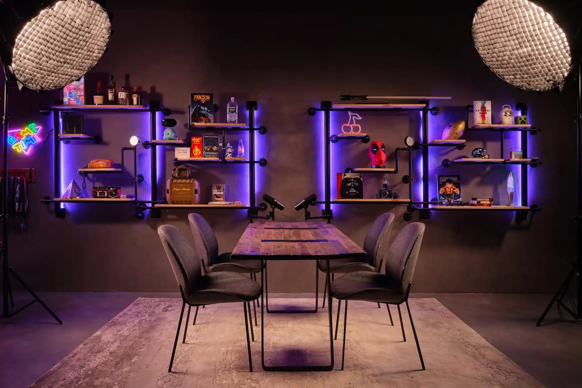 A studio table with two chairs, lit shelves and purple lighting