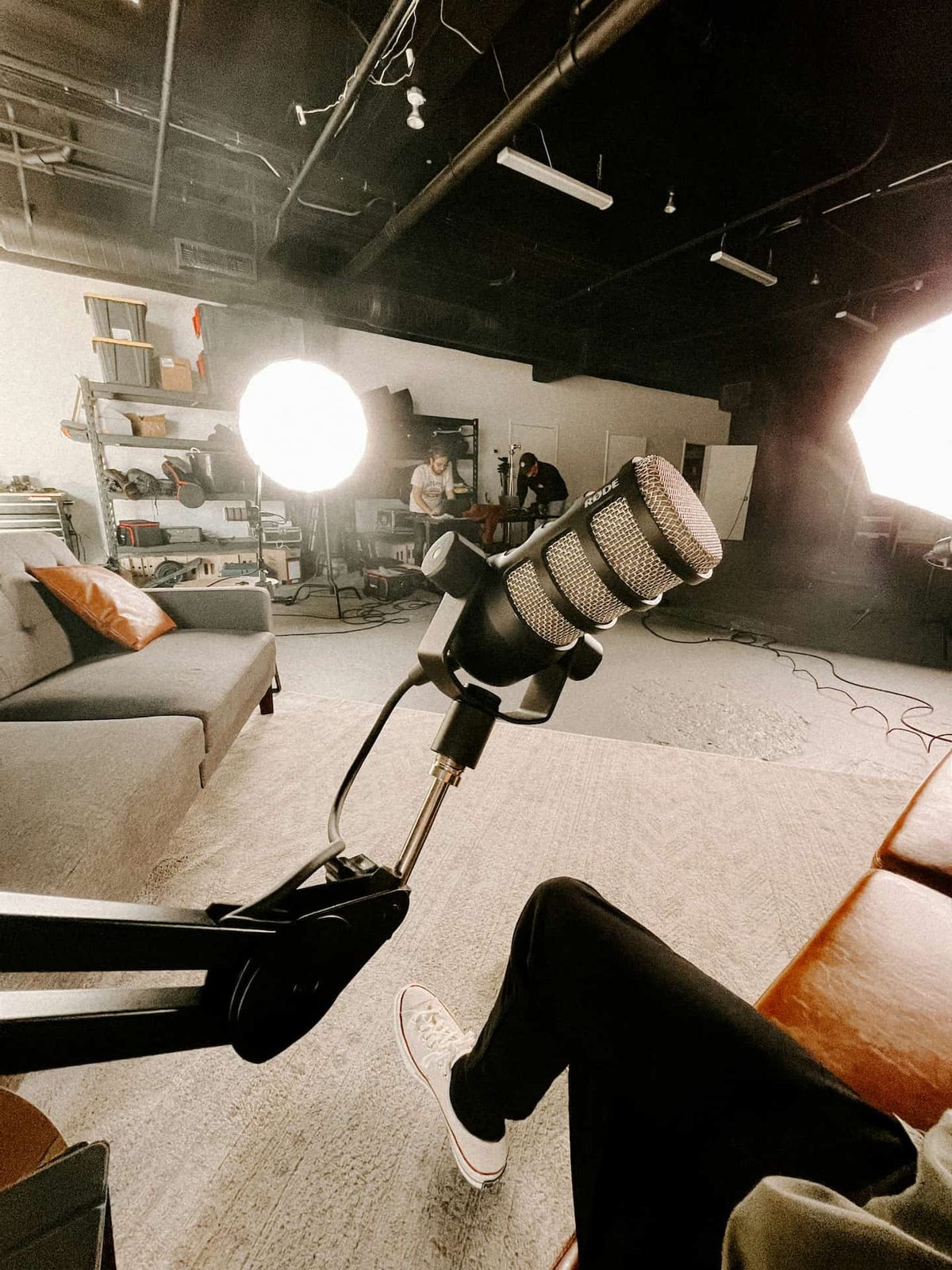 A microphone on a boom arm in a softly lit lounge studio