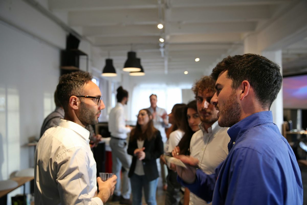 People talking in groups at a busy networking event