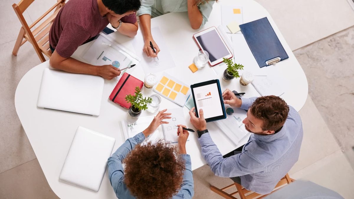 Four colleagues working around a round table, seen from above