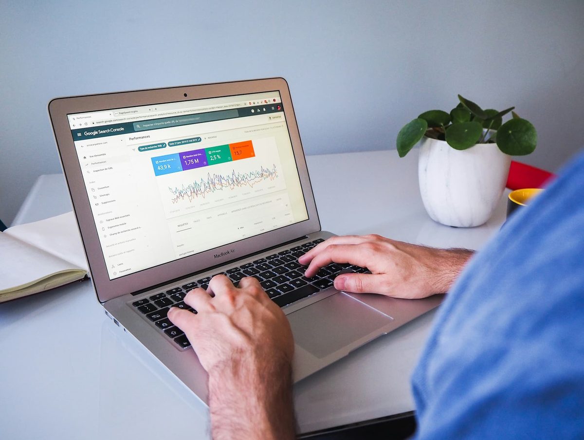 A person typing on a laptop showing a colourful schedule
