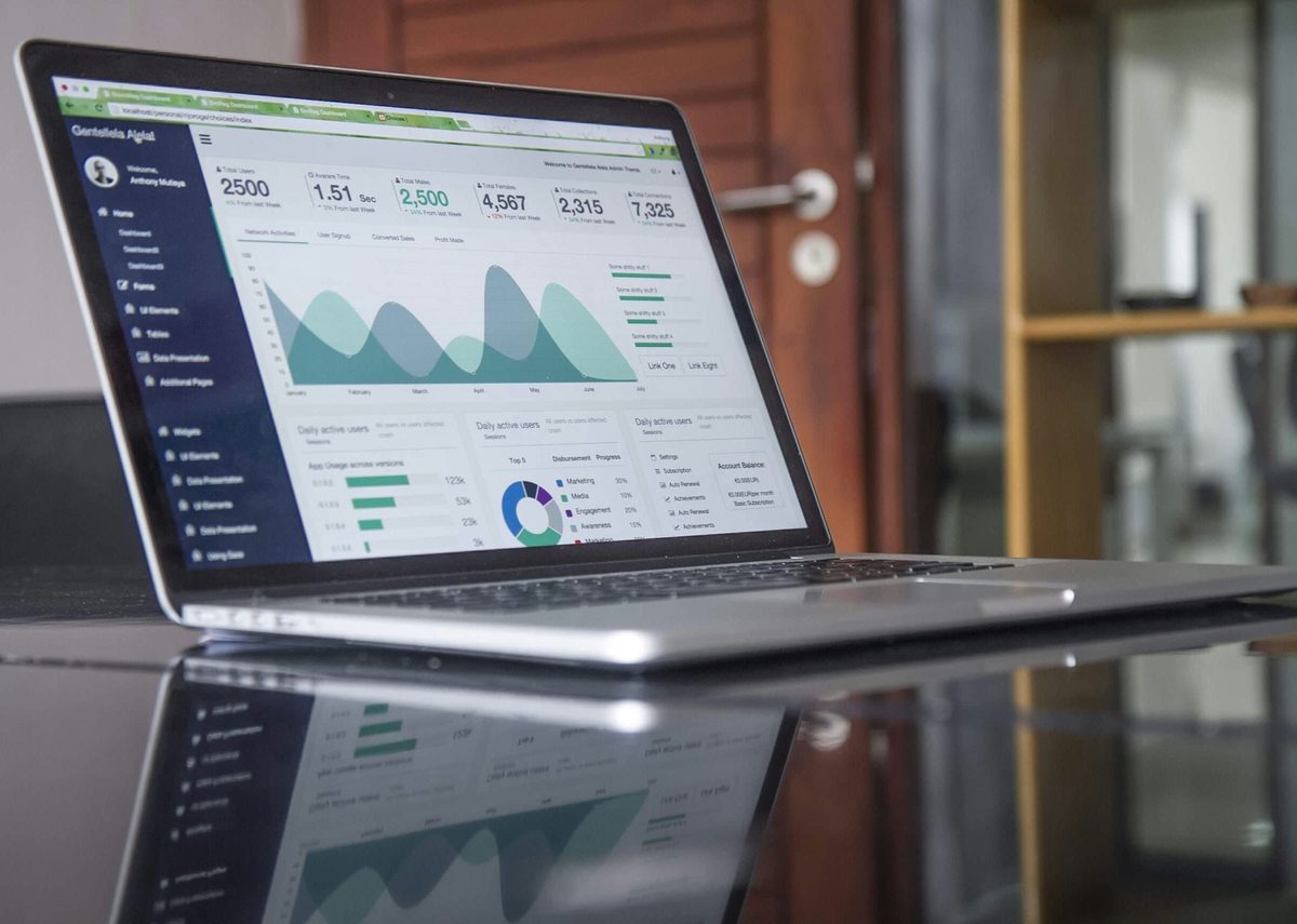 A laptop showing an analytics dashboard of charts and figures