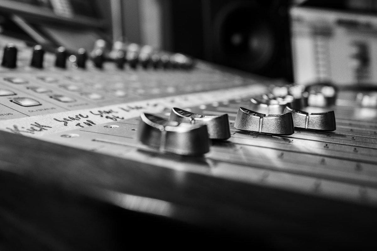 A close-up of a mixing desk, in black and white