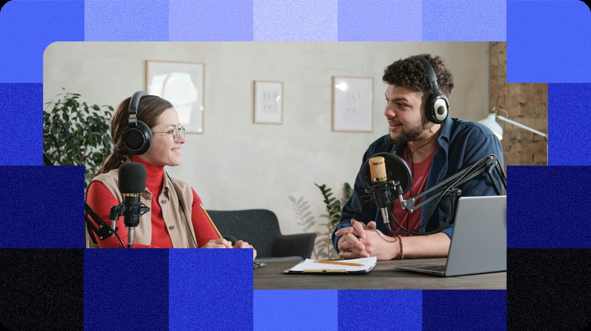 Two hosts talking over microphones in a bright studio, framed by a blue check pattern