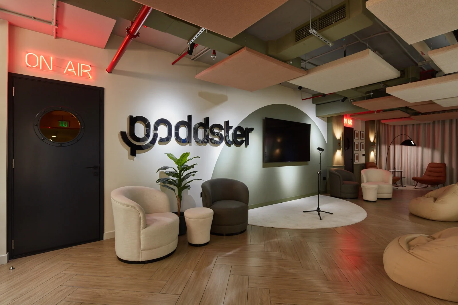 The Poddster studio lounge in Dubai, with the ON AIR sign over the studio door